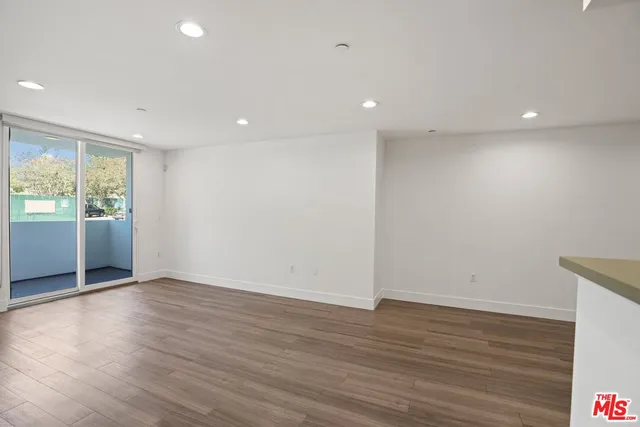an empty room with wooden floor and sliding door