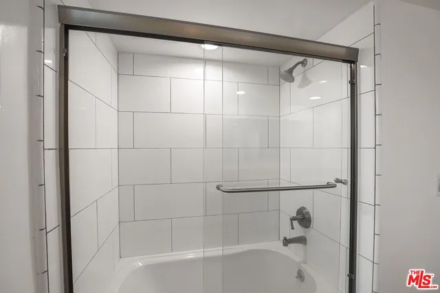 a bathroom with a shower and a bath tub