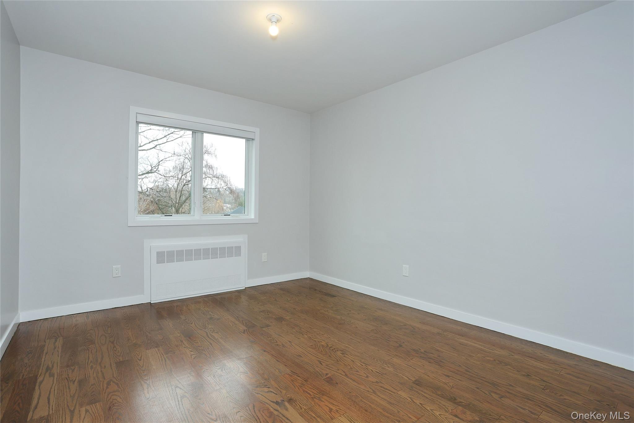 8 Neil Road, Unit 213 Spring Valley, NY 10977 - Photo 32 of 50 an empty room with wooden floor and windows