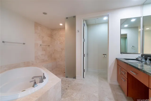 a spacious bathroom with a bathtub sink and mirror