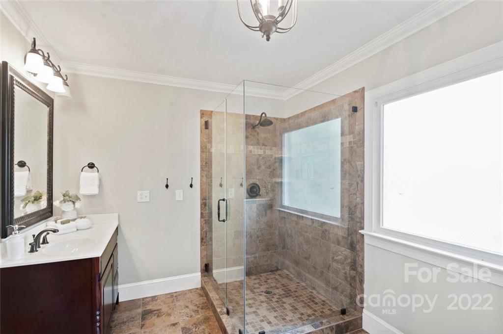 1435 Lilac Road Charlotte, NC 28209 - Photo 19 of 33 a bathroom with a shower a sink and a mirror