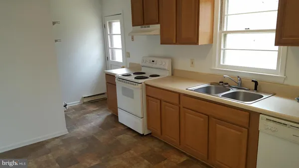 a kitchen with granite countertop a sink stove and cabinets