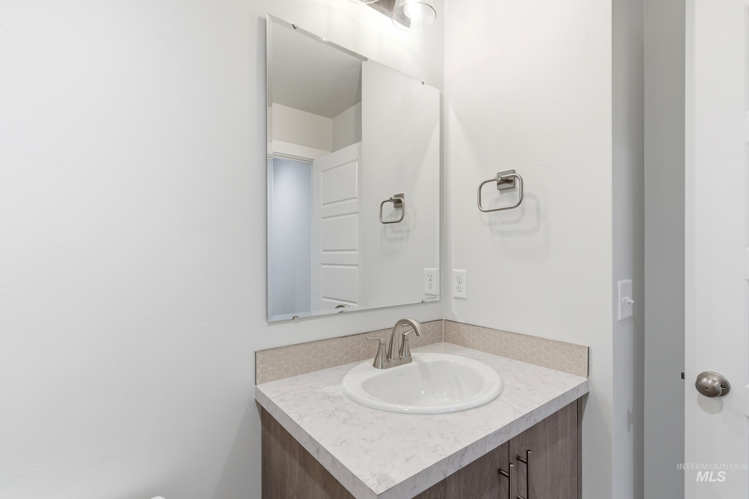 12829 Decatur Street Nampa, ID 83651 - Photo 16 of 33 Vanity with a built-in sink, brushed nickel faucet, and coordinating towel ring