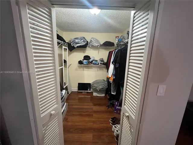 a view of a hallway with wooden floor and windows