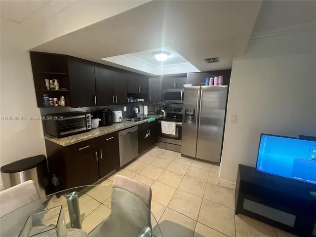 a kitchen with stainless steel appliances granite countertop a sink counter space and refrigerator