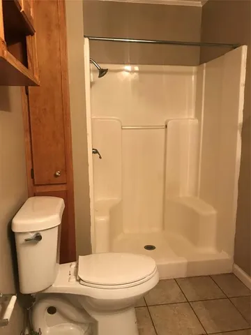 a bathroom with a toilet and a shower