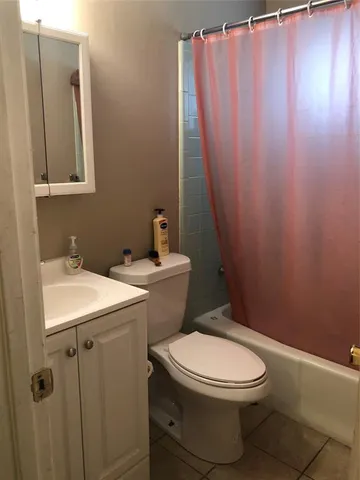 a bathroom with a sink a toilet and shower curtain