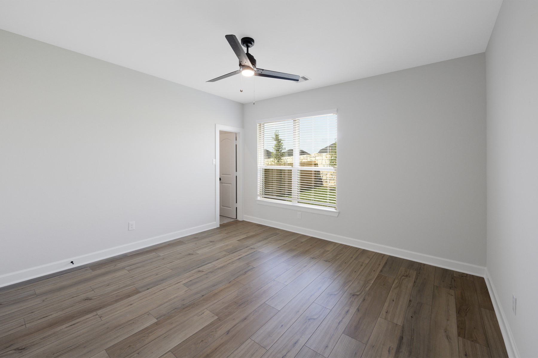 6213 White Spruce Drive Conroe, TX 77304 - Photo 7 of 21 wooden floor in an empty room with a window