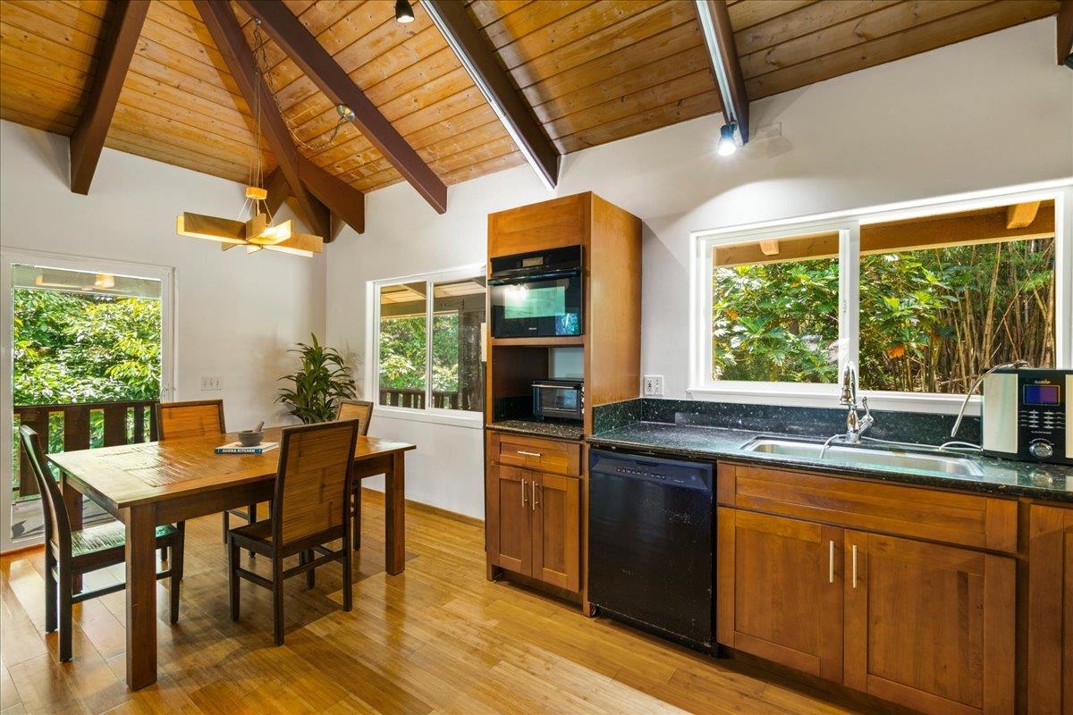 4510 Waha Place, Unit 2 Haiku, HI 96708 - Photo 13 of 36 a kitchen with stainless steel appliances granite countertop a stove a refrigerator a kitchen island a table and chairs in it