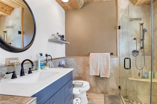 a bathroom with a sink vanity mirror and toilet