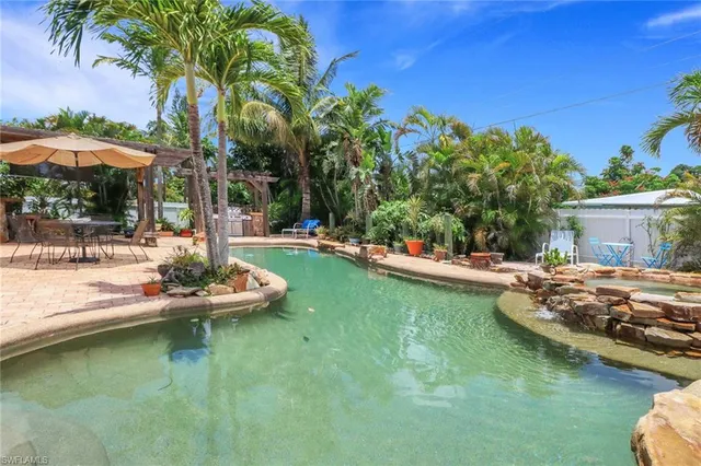 a view of a house with pool and chairs