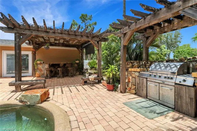 a view of a patio with table and chairs a barbeque