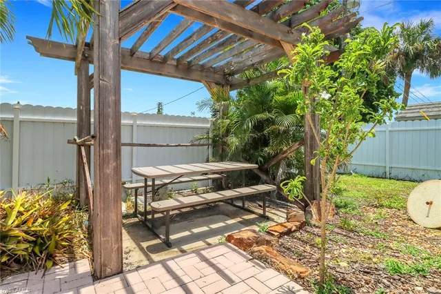 a backyard of a house with table and chairs wooden floor and fence