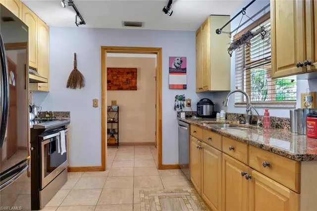 a kitchen with stainless steel appliances granite countertop a refrigerator and a sink