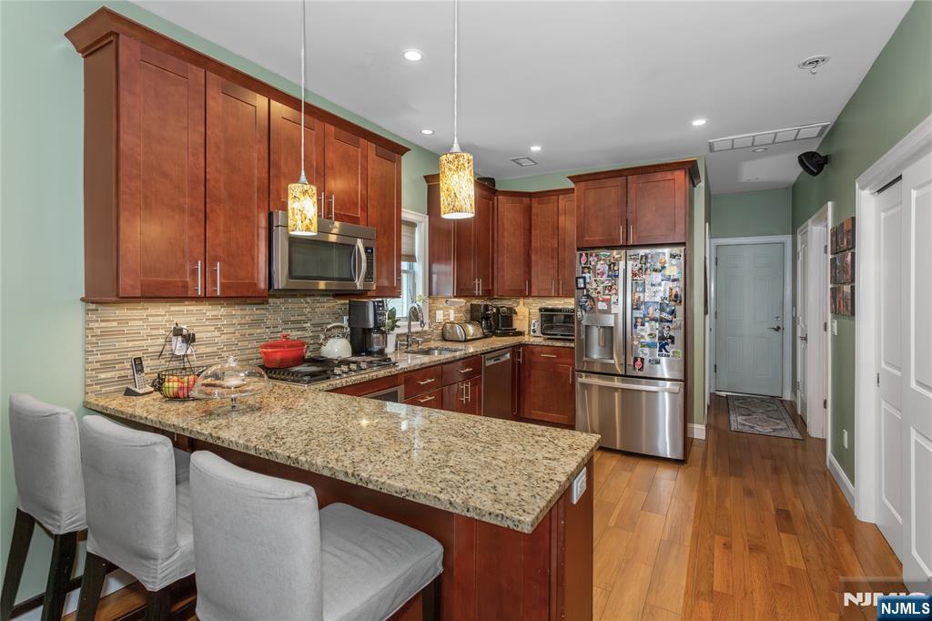 204 Hayward Place Wallington, NJ 07057 - Photo 17 of 39 a kitchen with stainless steel appliances granite countertop a sink refrigerator and cabinets