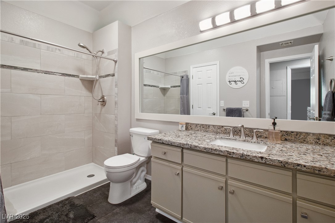 3550 Bay Sands Drive, Unit 2101 Laughlin, NV 89029 - Photo 21 of 49 Bathroom, accessible from the Primary Bedroom and via the Hallway. This bathroom has granite countertops, black tile flooring, a walk-in shower with handheld adjustable shower head, and a mirror sink vanity with modern light fixtures.