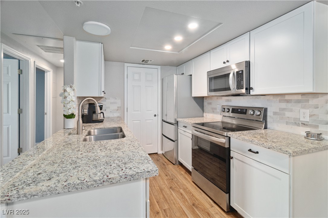 3550 Bay Sands Drive, Unit 2101 Laughlin, NV 89029 - Photo 7 of 49 Alternate angle of the Kitchen, showcasing the granite countertops and the tile backsplash. Also pictured is the modern recessed ceiling light fixtures.