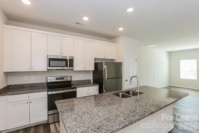 a bathroom with a granite countertop bathtub shower and toilet