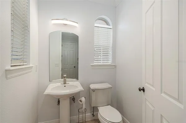 a bathroom with a sink a toilet and a mirror