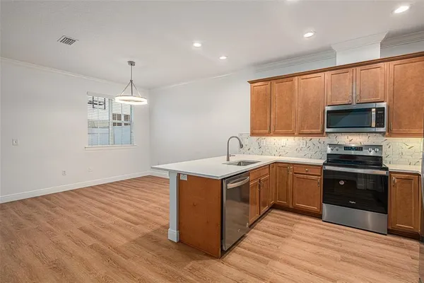 a kitchen with stainless steel appliances granite countertop a sink stove and refrigerator