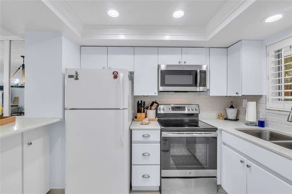 1198 Hillsboro Mile, Unit 212 Hillsboro Beach, FL 33062 - Photo 12 of 64 a kitchen with white cabinets and stainless steel appliances