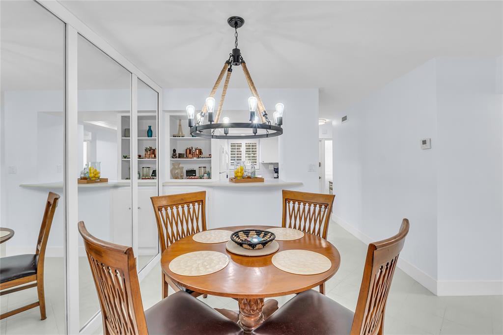 1198 Hillsboro Mile, Unit 212 Hillsboro Beach, FL 33062 - Photo 15 of 64 a dining room with furniture wooden floor and a chandelier
