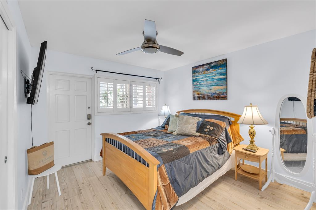 1198 Hillsboro Mile, Unit 212 Hillsboro Beach, FL 33062 - Photo 28 of 64 a bedroom with a bed and wooden floor
