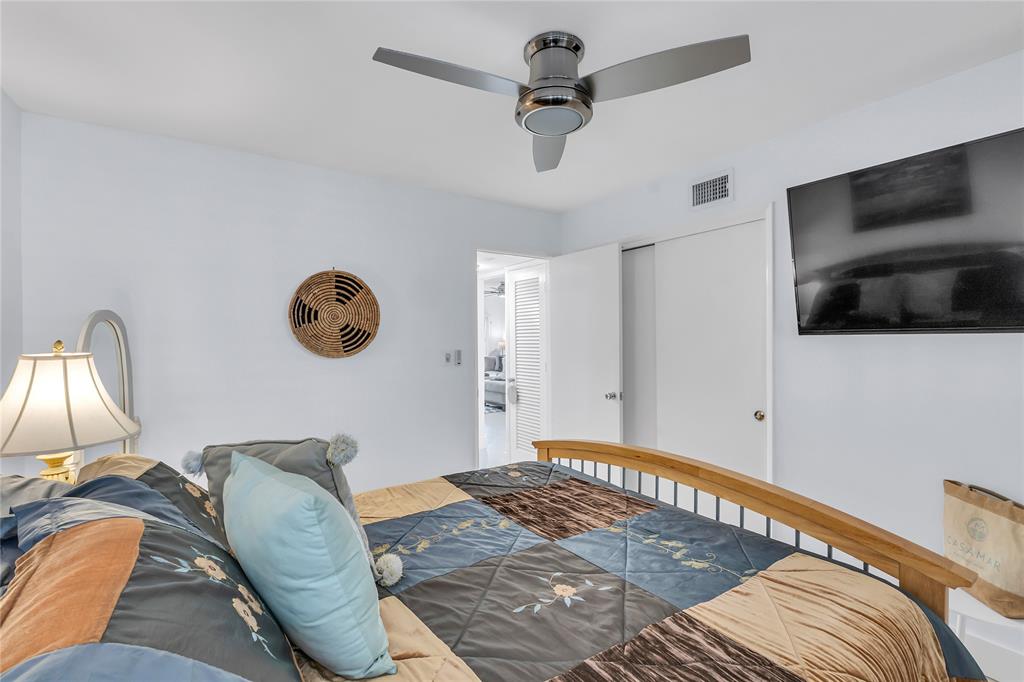 1198 Hillsboro Mile, Unit 212 Hillsboro Beach, FL 33062 - Photo 30 of 64 a bedroom with a bed and a flat screen tv