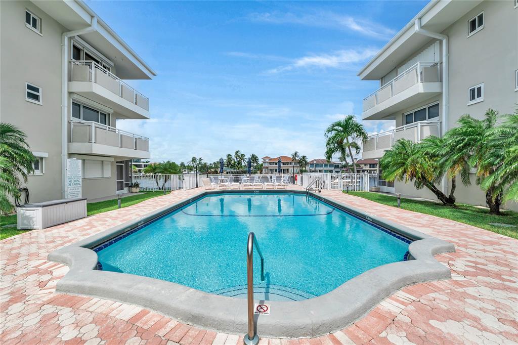 1198 Hillsboro Mile, Unit 212 Hillsboro Beach, FL 33062 - Photo 42 of 64 a swimming pool with outdoor seating and yard
