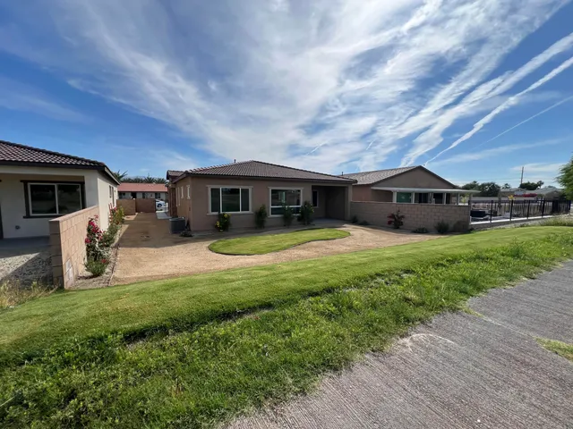 a view of house with a yard and sitting area
