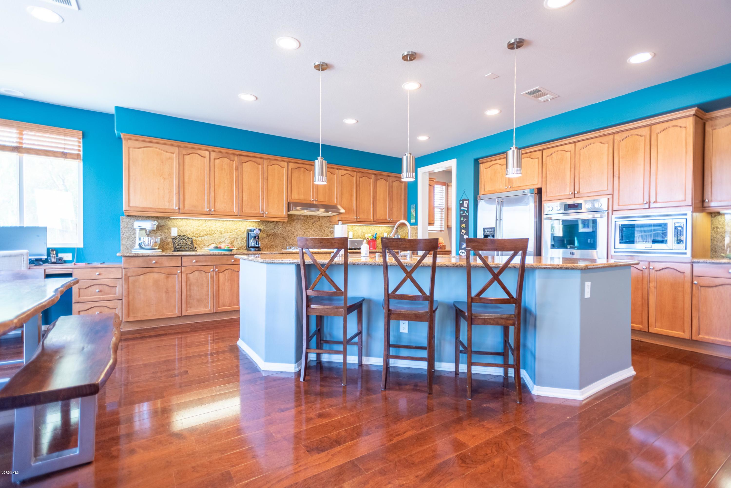 17118 Raindrop Court Riverside, CA 92503 - Photo 18 of 68 a kitchen with stainless steel appliances wooden floor dining table and chairs