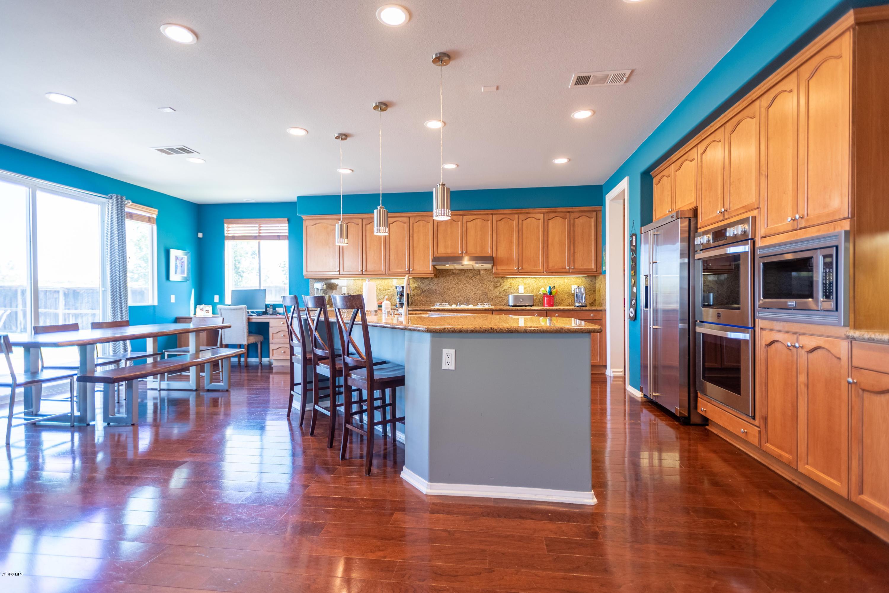 17118 Raindrop Court Riverside, CA 92503 - Photo 19 of 68 a kitchen with stainless steel appliances granite countertop a refrigerator a stove top oven a dining table and chairs