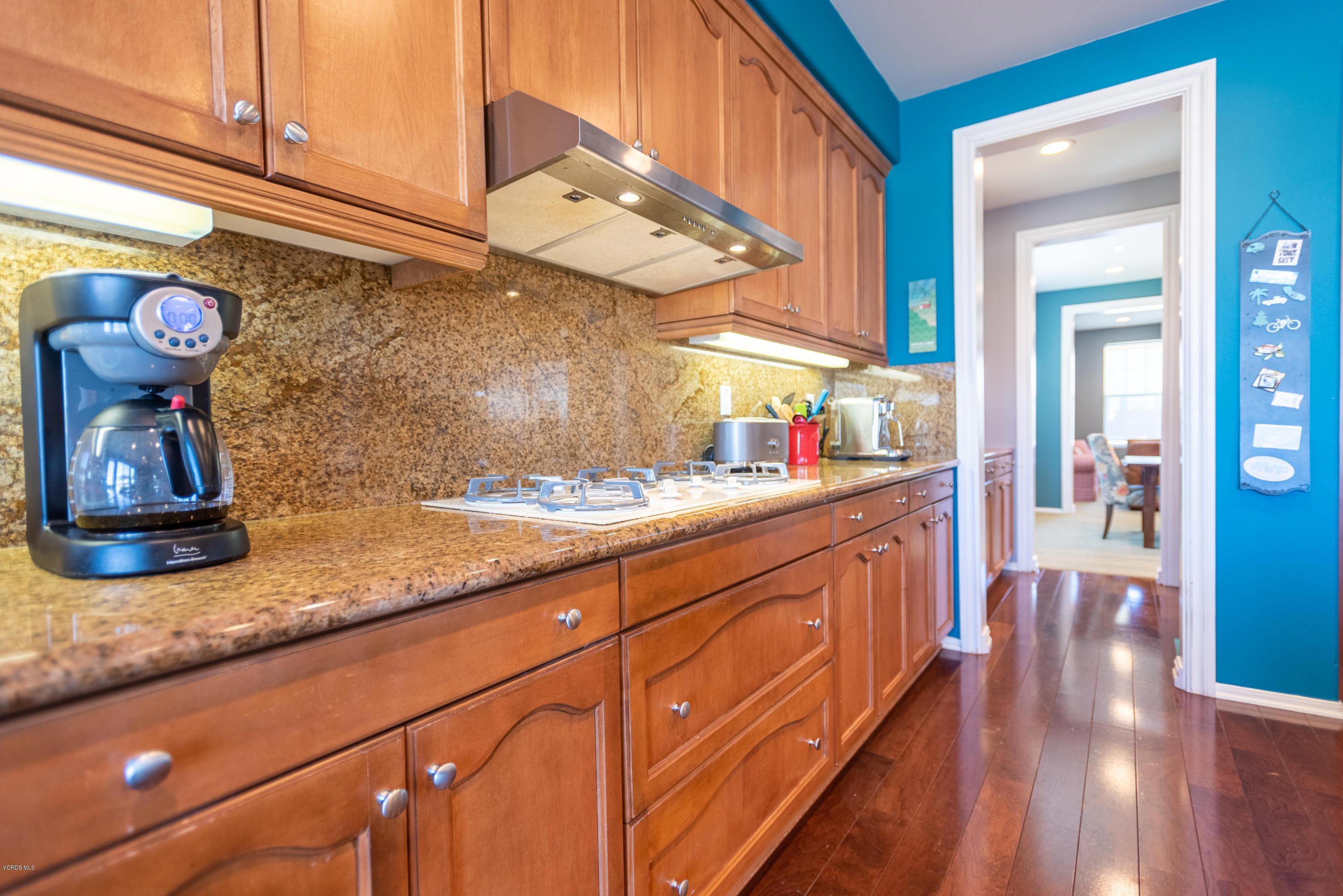 17118 Raindrop Court Riverside, CA 92503 - Photo 23 of 68 a kitchen with kitchen island granite countertop wooden cabinets a sink and dishwasher