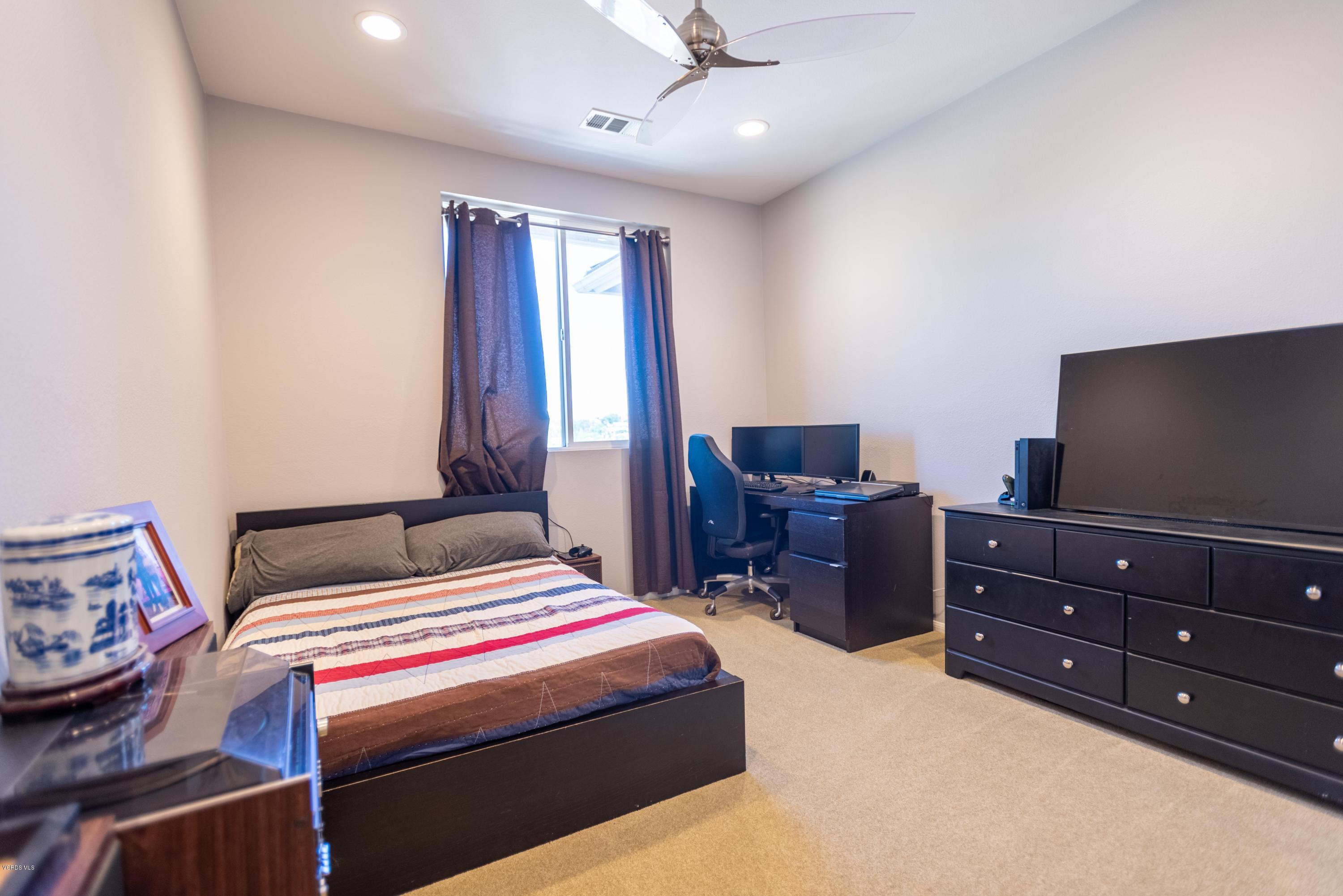 17118 Raindrop Court Riverside, CA 92503 - Photo 50 of 68 a bedroom with a bed and a flat screen tv