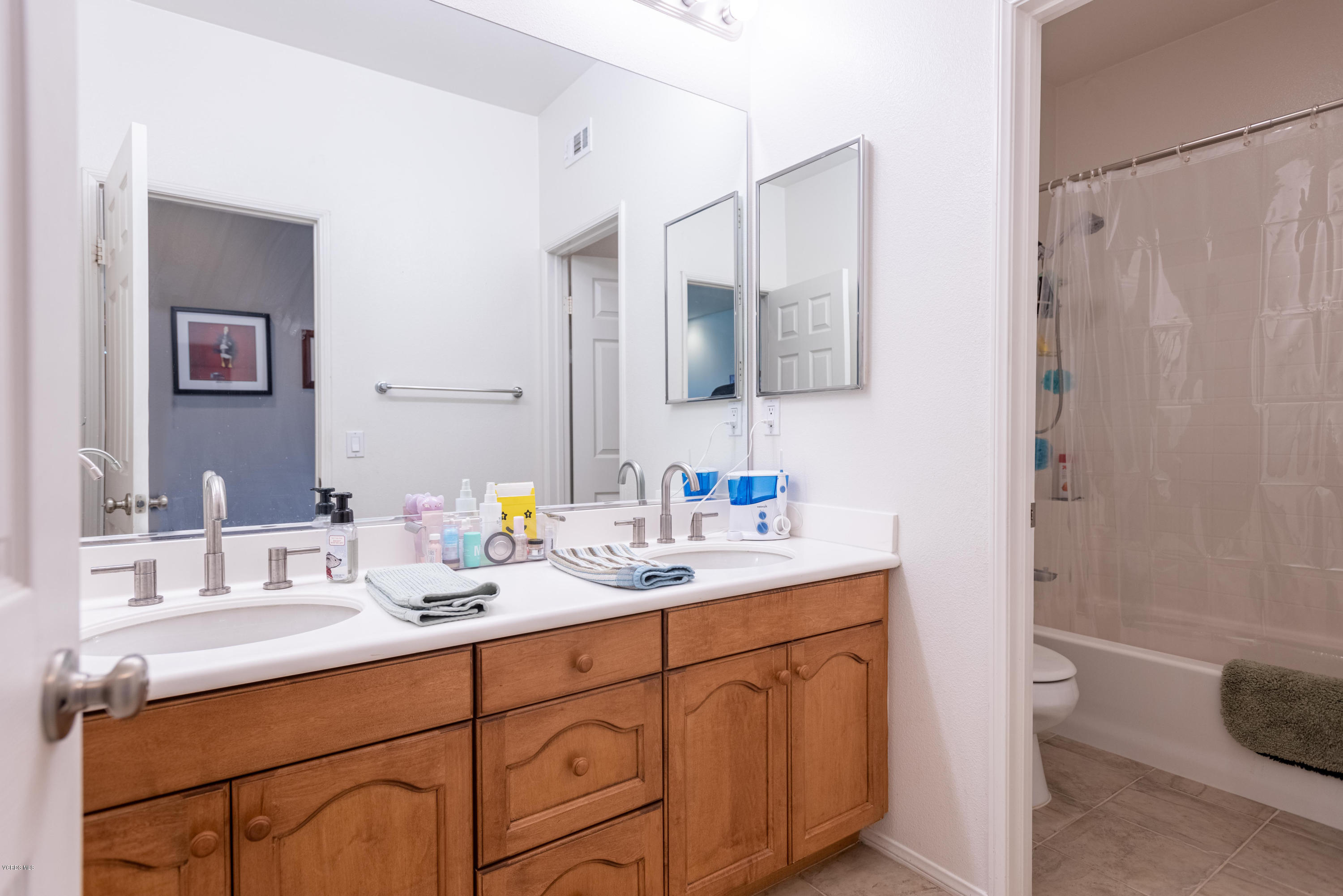 17118 Raindrop Court Riverside, CA 92503 - Photo 53 of 68 a bathroom with double vanity sink a mirror and a shower