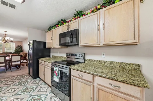 a kitchen with stainless steel appliances granite countertop a stove microwave sink and refrigerator