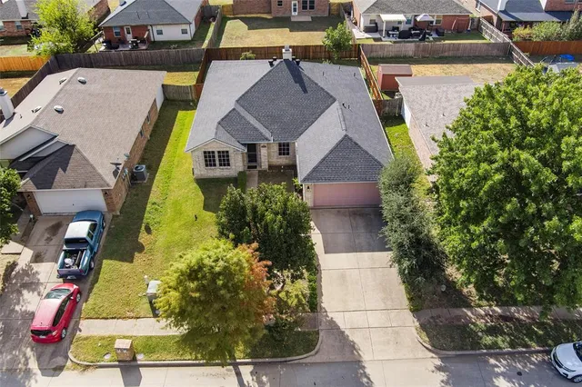 an aerial view of a house with swimming pool and large trees