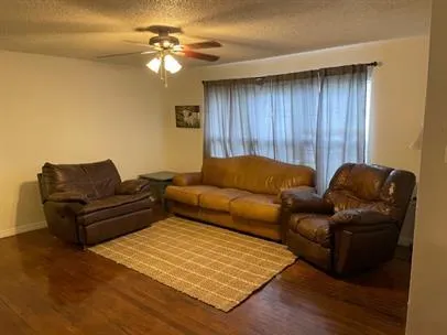 a living room with furniture and a ceiling fan