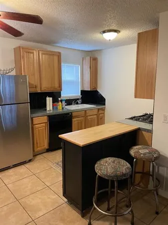 a kitchen with a stove a sink a refrigerator and a dining table