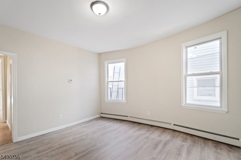 874 South 16th Street Newark, NJ 07108 - Photo 16 of 29 an empty room with wooden floor and windows