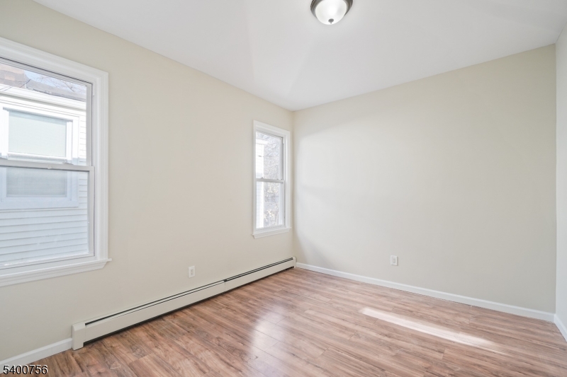 874 South 16th Street Newark, NJ 07108 - Photo 18 of 29 an empty room with wooden floor and windows