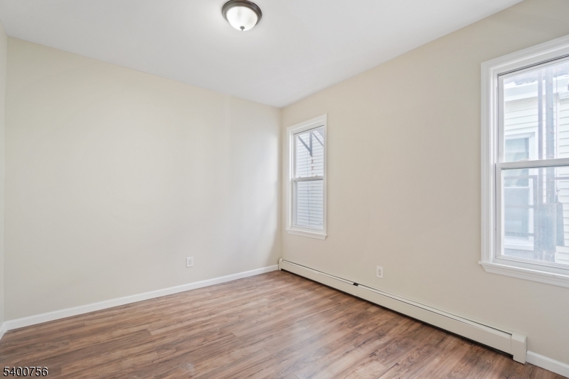 874 South 16th Street Newark, NJ 07108 - Photo 22 of 29 an empty room with wooden floor and windows