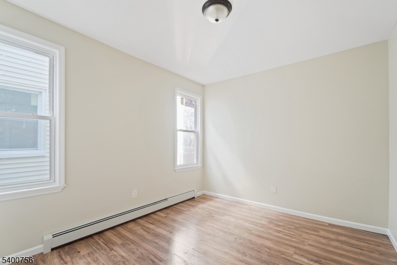 874 South 16th Street Newark, NJ 07108 - Photo 24 of 29 an empty room with wooden floor and windows