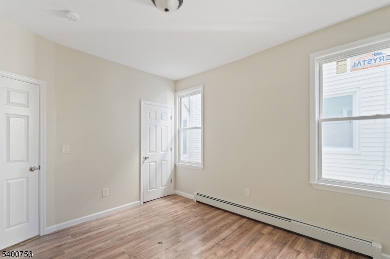 874 South 16th Street Newark, NJ 07108 - Photo 8 of 29 an empty room with wooden floor and windows