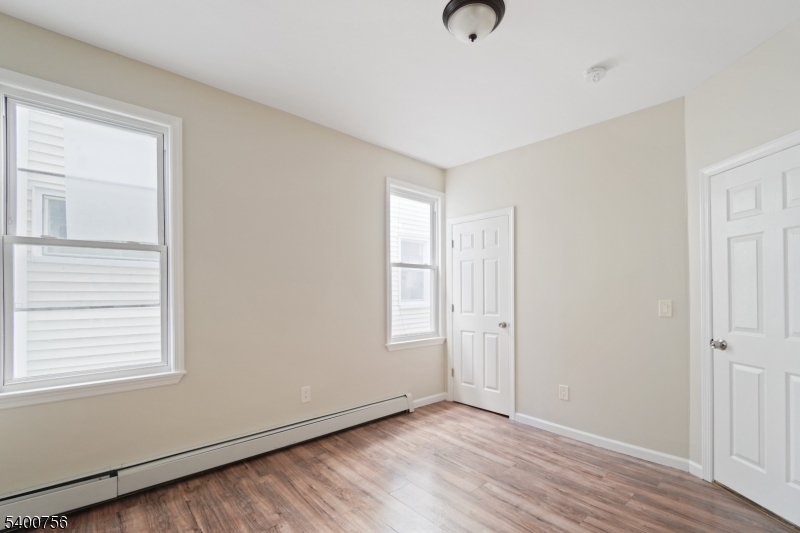 874 South 16th Street Newark, NJ 07108 - Photo 9 of 29 an empty room with wooden floor and windows