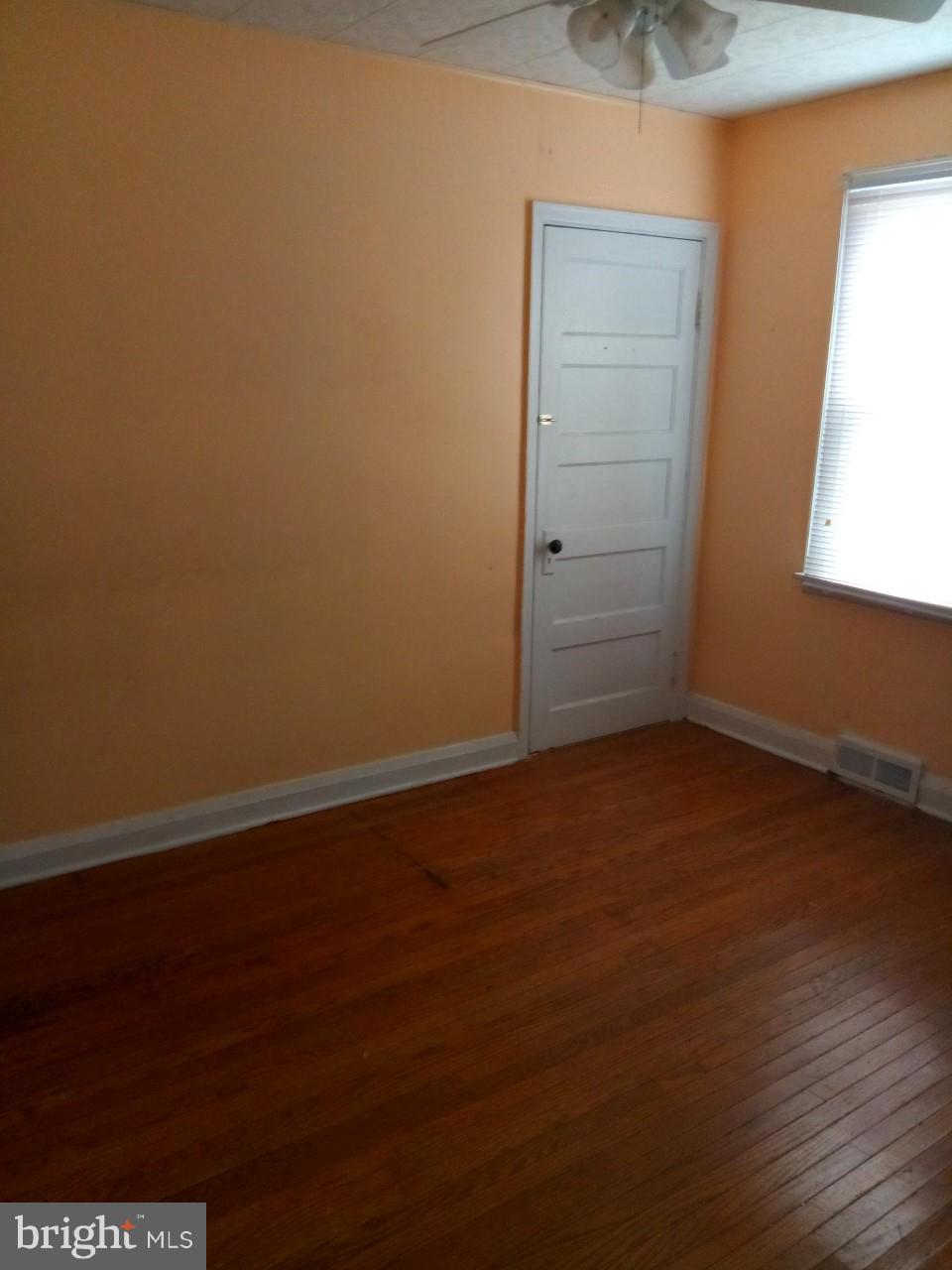 3321 Fairview Road Baltimore, MD 21207 - Photo 7 of 12 an empty room with wooden floor and windows