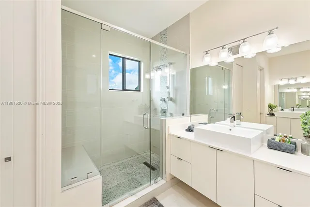 a bathroom with a shower sink and mirror