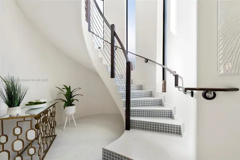 a view of entryway with wooden floor and vase sitting on a table