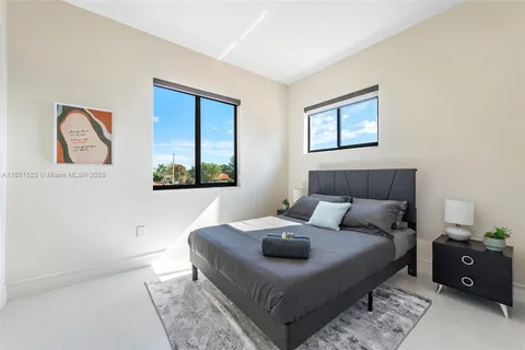 a bedroom with a bed and a lamp on dresser