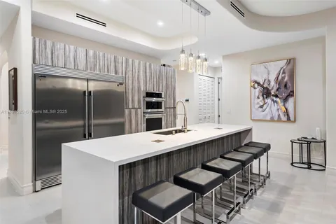 a kitchen with kitchen island a refrigerator dining table and chairs